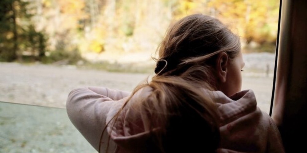 A woman resting a hand on her chest in a calm moment of self-reflection