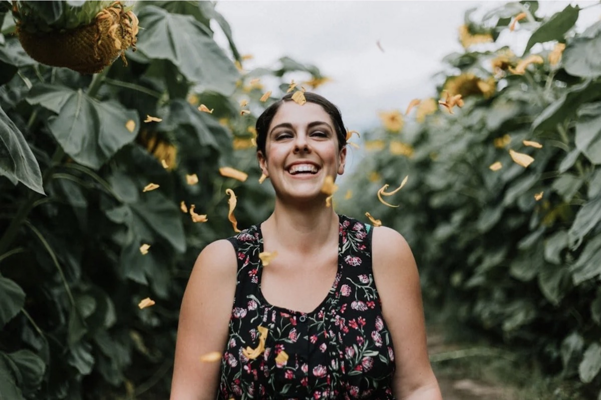 A smiling woman among sunflowers